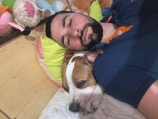 Man and dog rest together on blanket in Belene