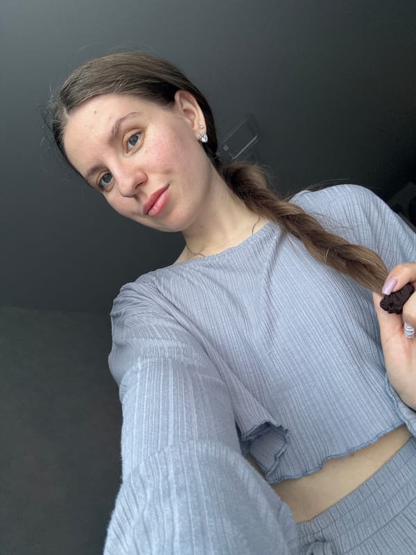 Woman holds hair tie during grooming moment in Klin