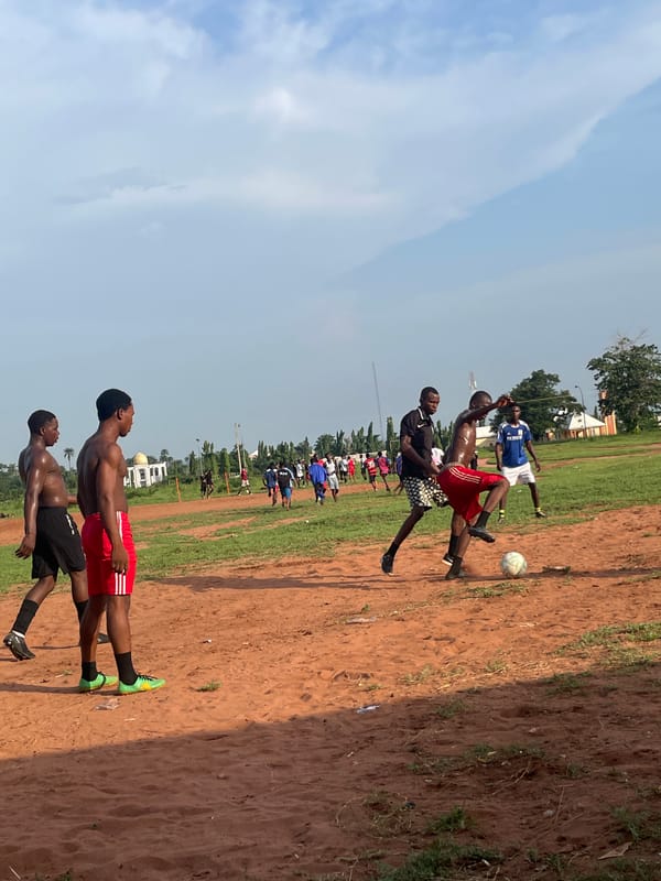 Casual soccer match on dirt field in Ogbogbo, Nigeria