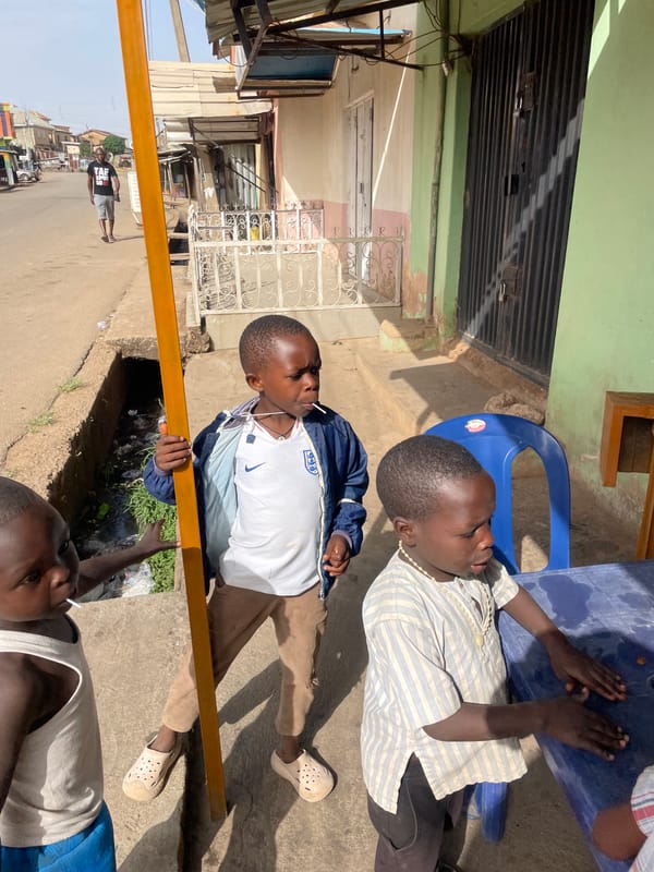 Boys gather at outdoor table in Jos, Nigeria