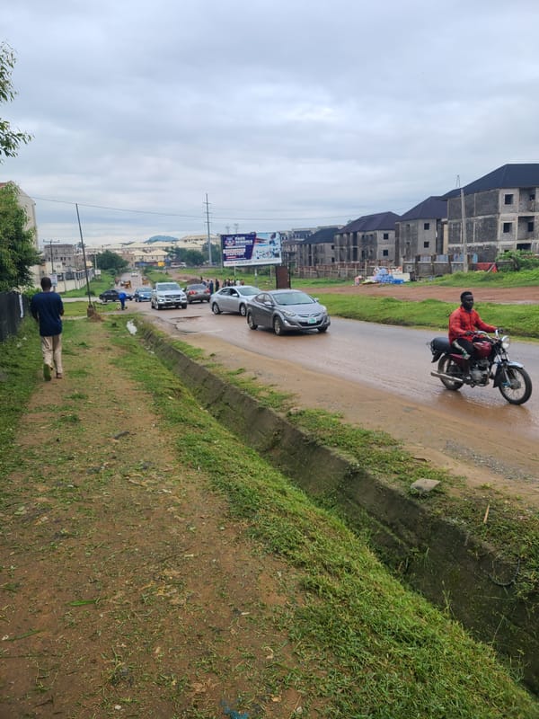 Wet streets and dirt paths on a grey morning in Abuja