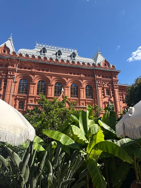 Historic Moscow brick building and palm fronds, seconds apart
