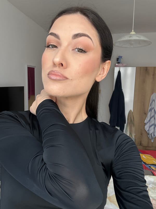 Woman photographs herself indoors wearing black shirt