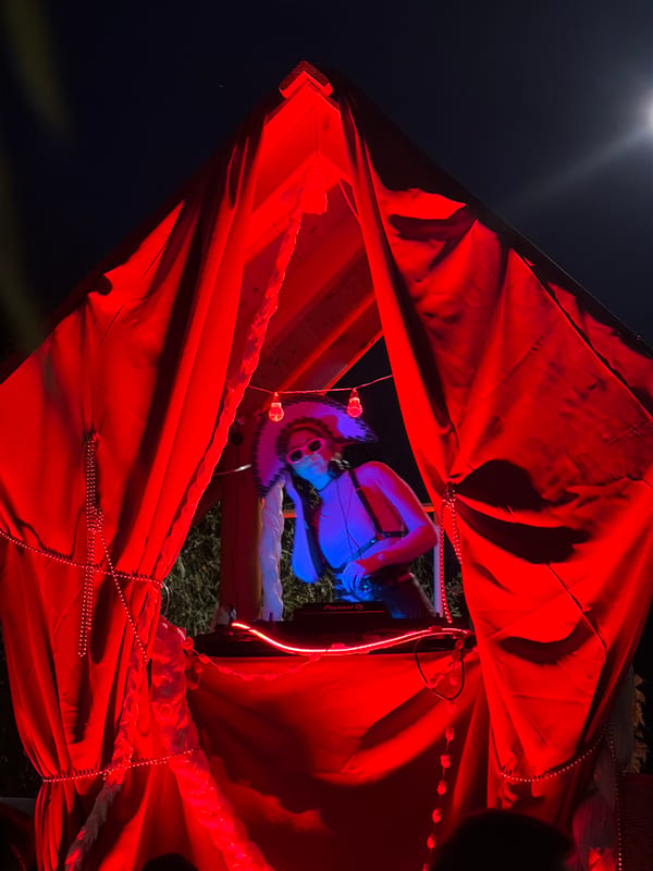 Masked DJ performs under red and blue lights in Moscow