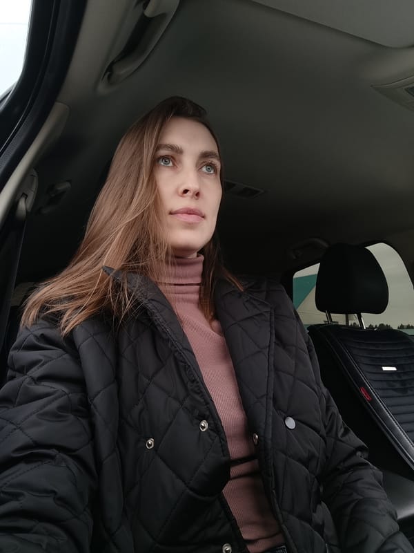 Woman sits in car adjusting hair in Фоки, Russia