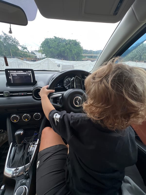 Child plays driver during family car outing, multiple angles captured