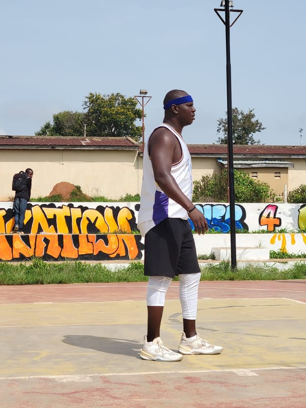 Outdoor pickup basketball on a red-and-yellow urban court