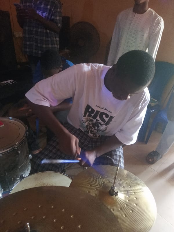 Young people hold informal indoor music session with multiple instruments