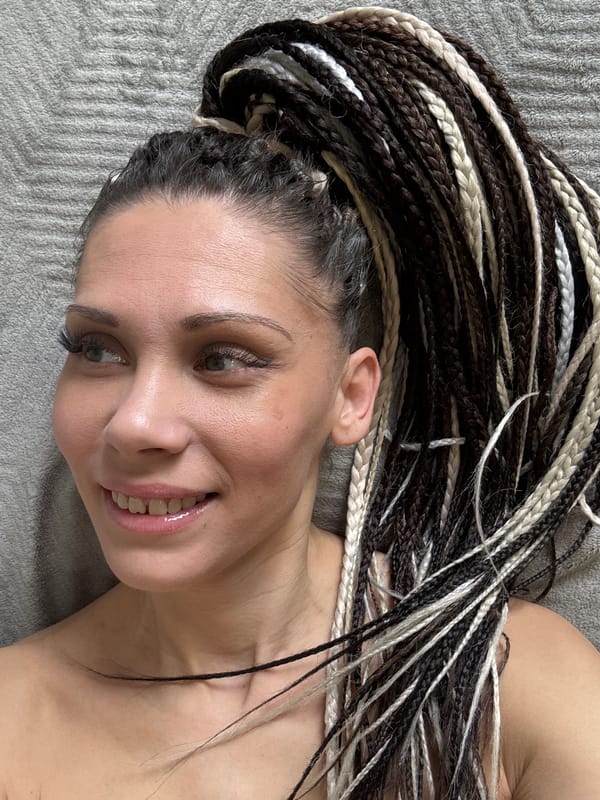 Person with braided hair rests on fabric surfaces