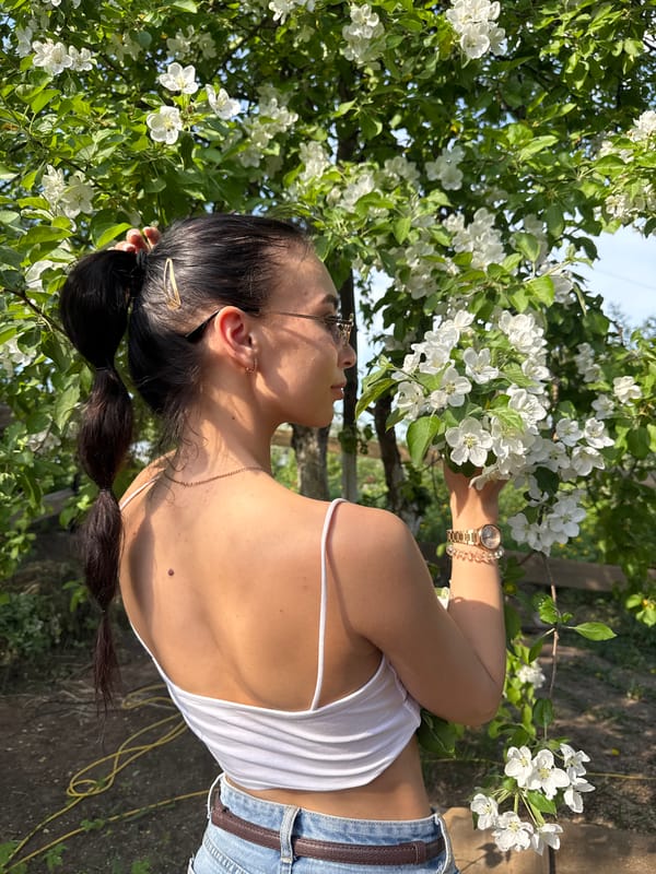Woman poses for spring photo session among apple blossoms