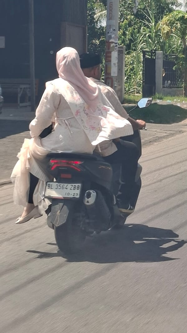 Scooter ride through a sunny Indonesian village street
