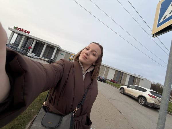 Woman takes selfie outside OK'EJ building in Klin, Russia