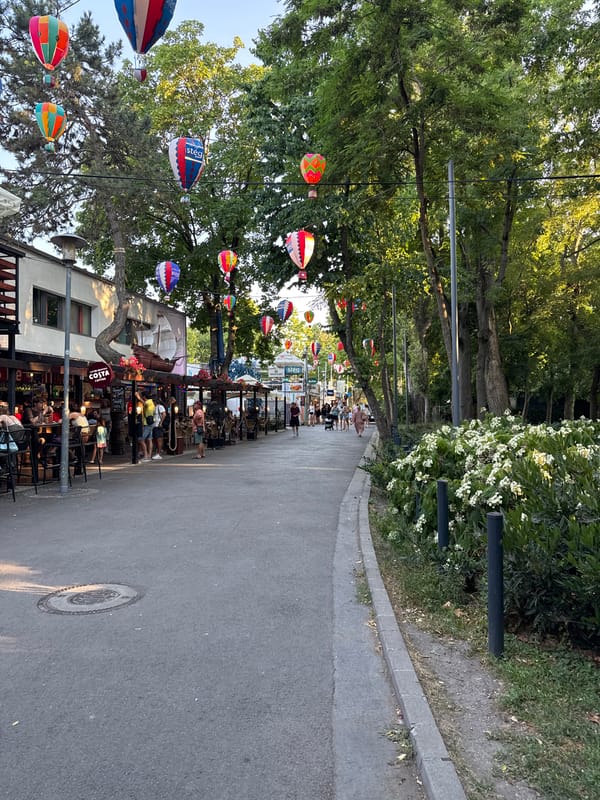 Budapest street festival with decorations, food stalls, and city sign