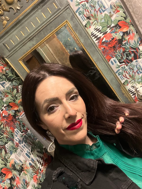 Woman in green blouse observed smiling indoors in Konz