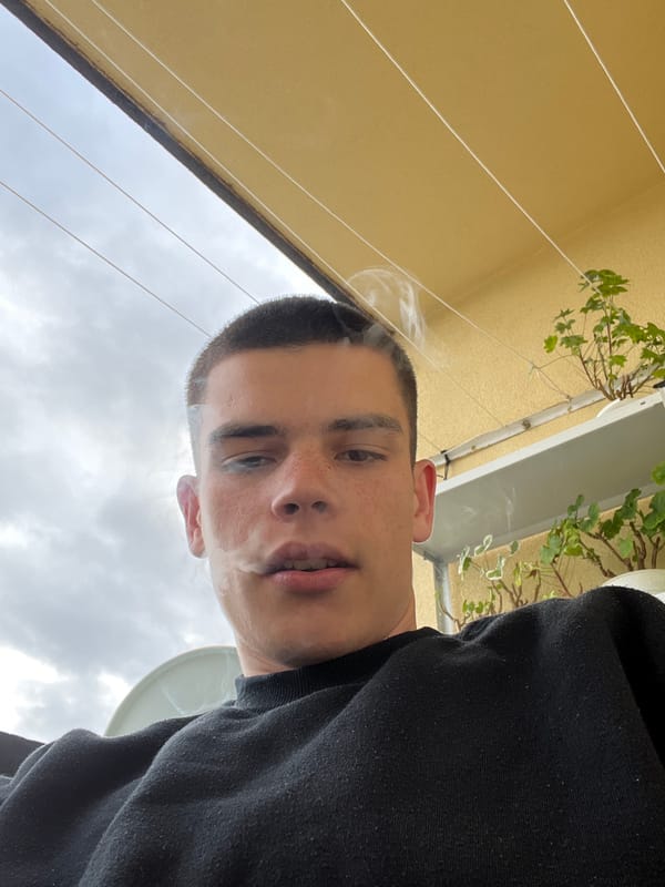 Young man smoking on balcony in Sopot, Bulgaria