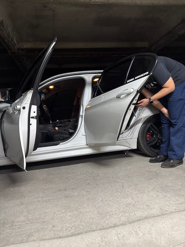 Two people tend to silver car in Sliven garage