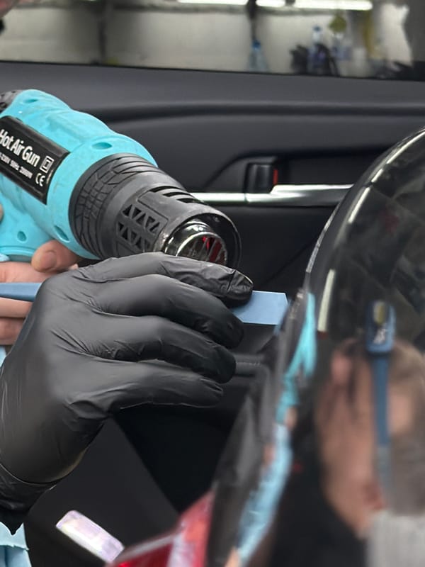 Person uses heat gun on car trim in Krasnoyarsk