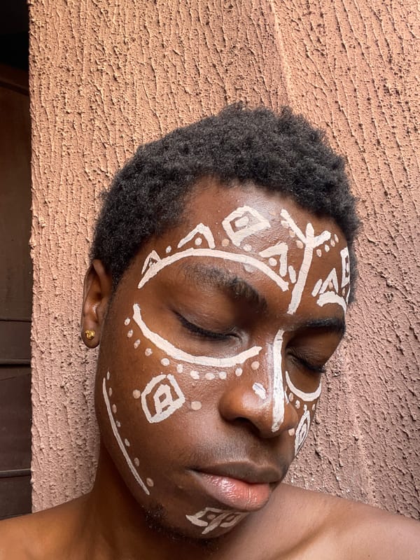 Person with tribal face paint rests in Nkpor, Nigeria