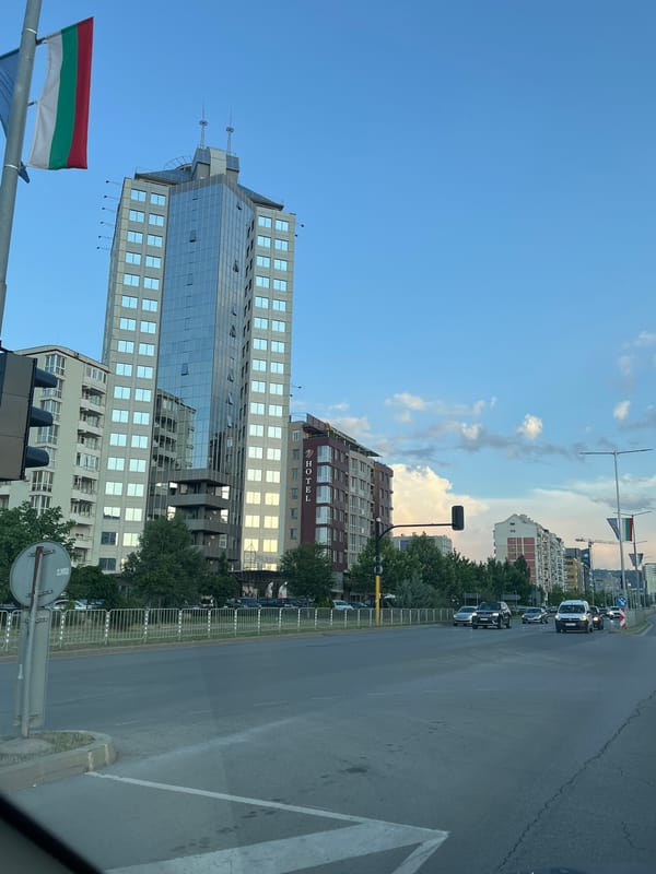 City streets, modern skyline, and a tricolor flag in view