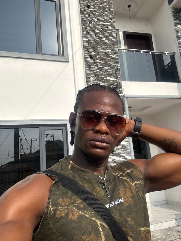 Man takes selfie outside modern building in Iranla, Nigeria