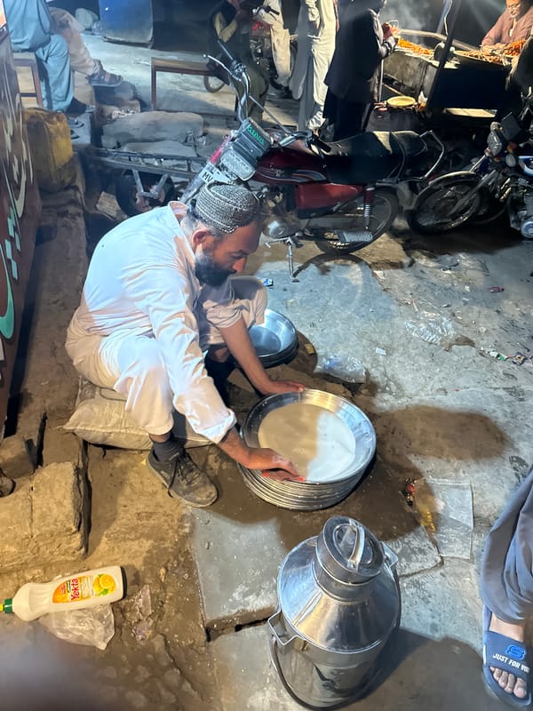 Man in traditional dress works near container in Quetta