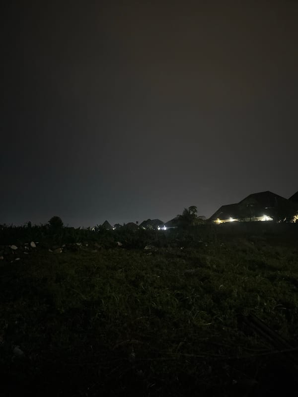 Wet Abuja streets and gated homes late on a rainy night