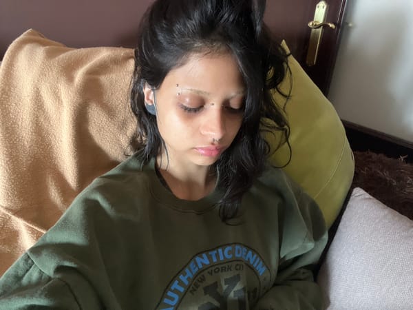Woman with facial piercings resting indoors in Spanish coastal town