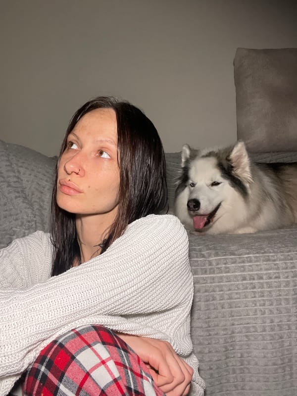 Woman rests with husky dog at home in Pervomaysky