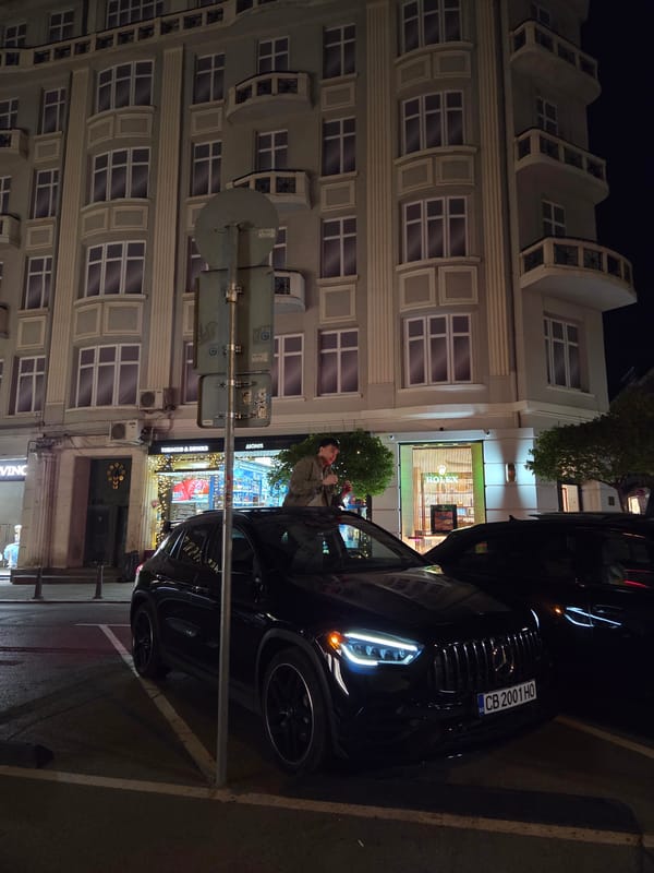 Men stand through sunroofs of luxury cars in Sofia