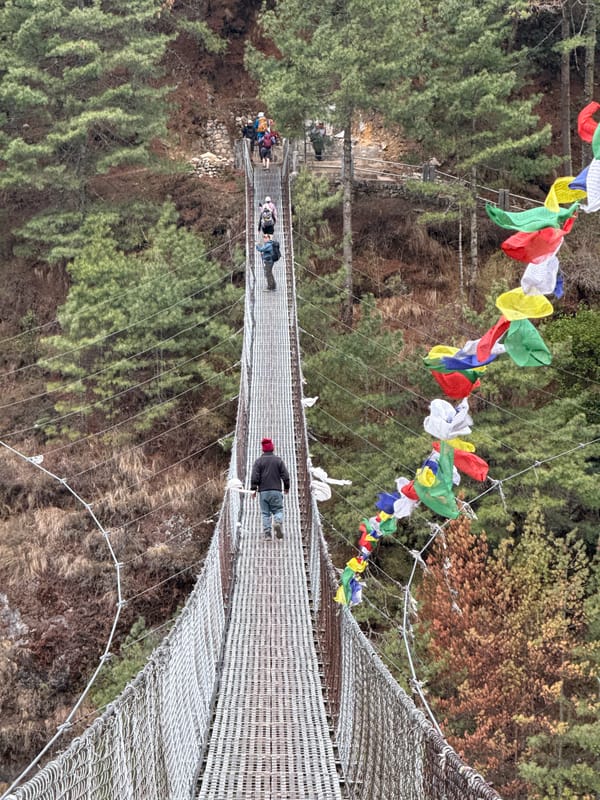 Hikers cross suspension bridges on Nepal mountain trails