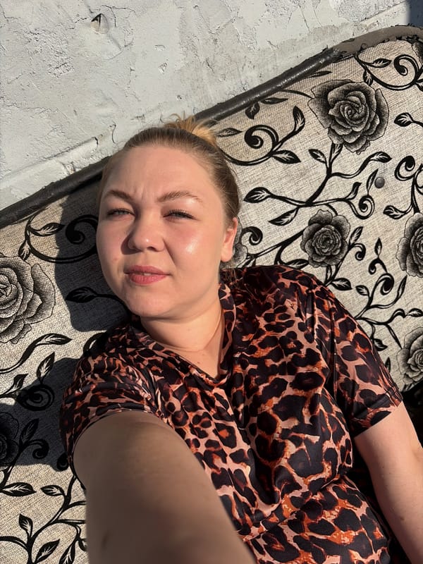 Woman rests on floral sofa in Noviy, Russia