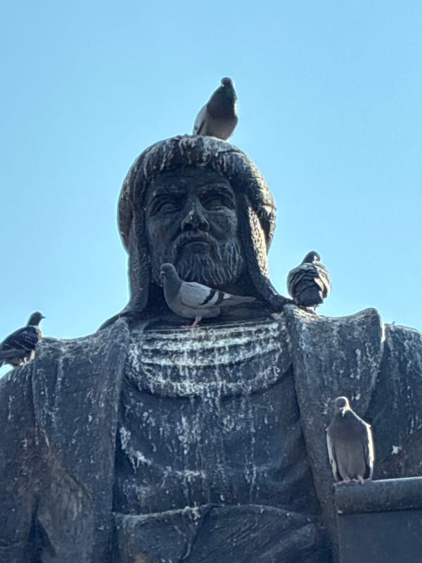 Pigeon-filled square around a historical statue in Alanya