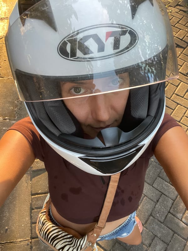 Person with motorcycle helmet spotted on sunlit city walkway
