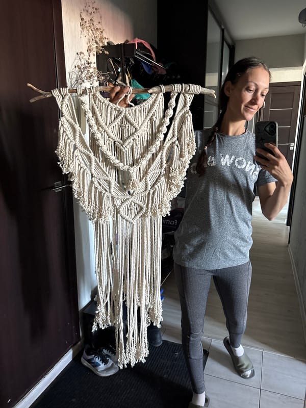 Woman displays handmade macrame artwork in Ulyanovsk home