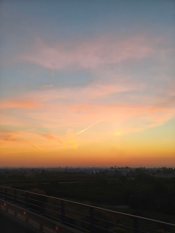 Sunset captured over Alcàsser, Spain with contrails and bridge