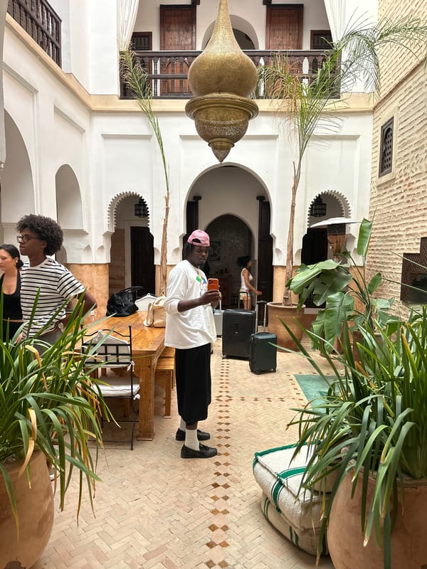Man checks phone in courtyard garden, Marrakesh