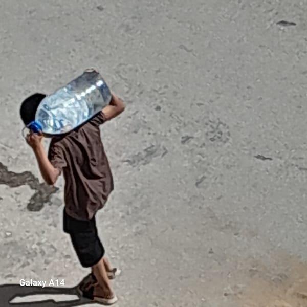 Residents carry water containers through Khan Yunis streets