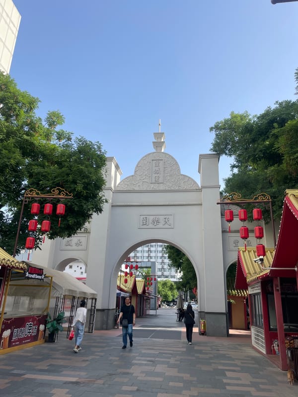 Nighttime street activity recorded at decorated archway in Xincheng District