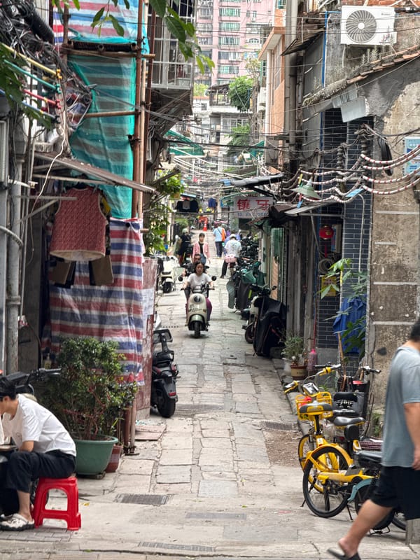 Motorbikes crowd narrow stone alley in Liwan District