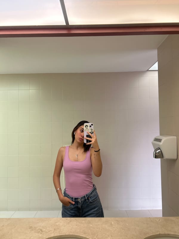Woman takes bathroom mirror selfies in tiled room