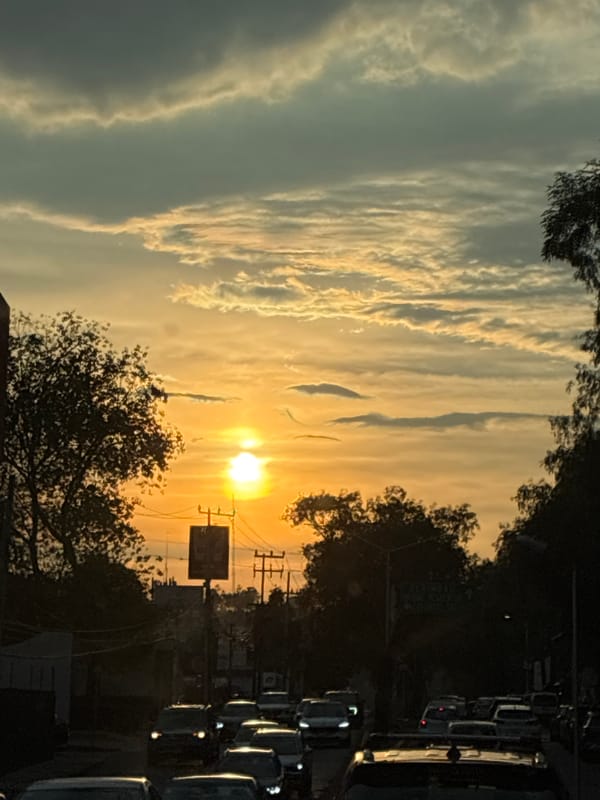 Sunset illuminates Naucalpan de Juárez streets amid evening traffic