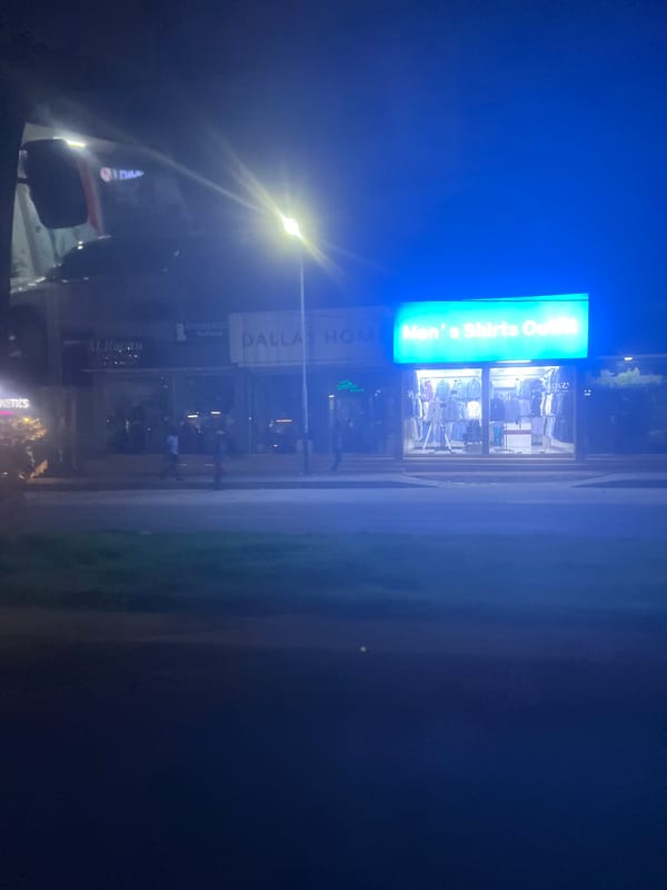 Illuminated storefronts observed at night in Dar es Salaam