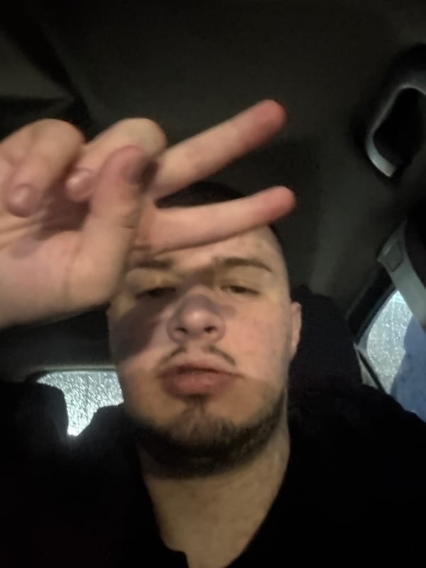 Man makes peace sign in car during rain