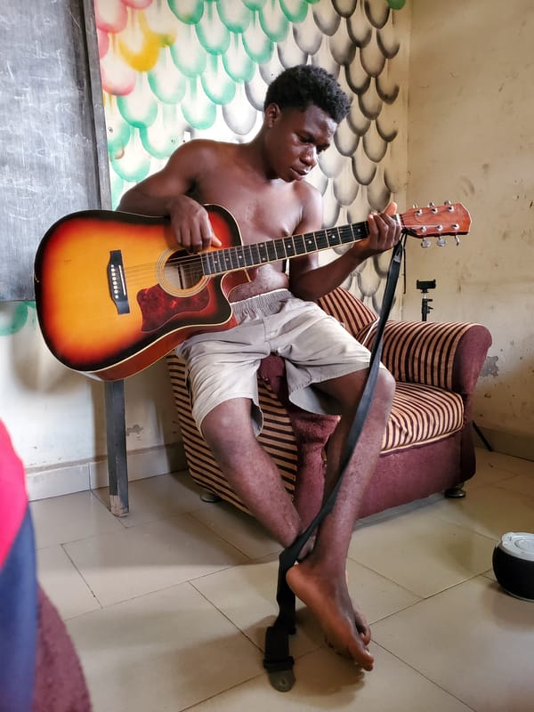 Young musician plays guitar in Mararaba home session