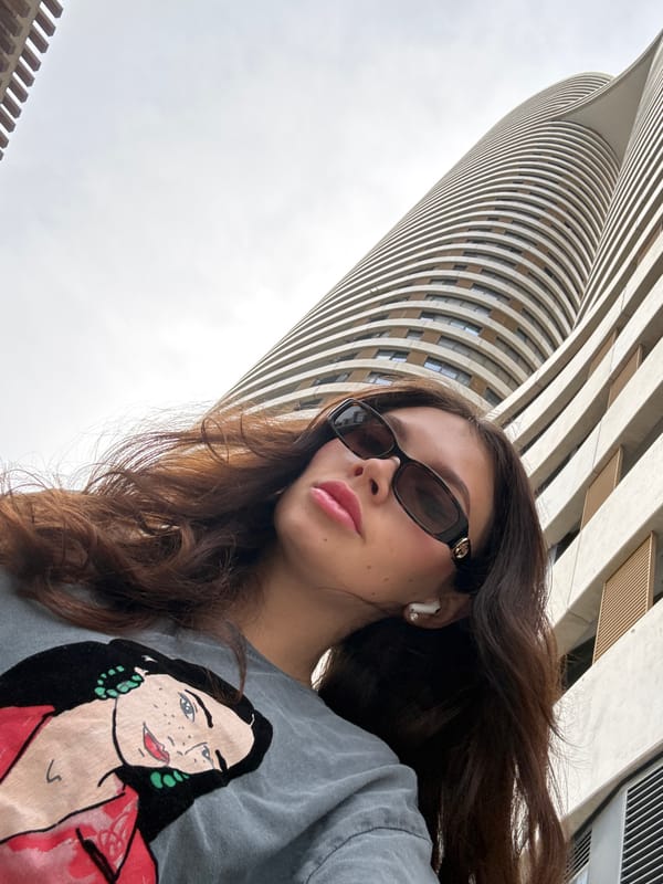 Woman photographed against curved building backdrop in Tel Aviv