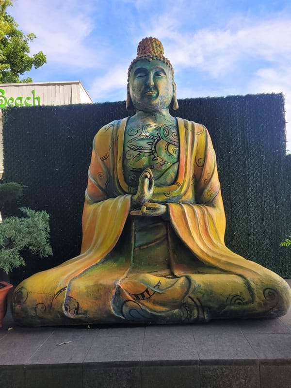 Beach day and resort vibes with a Buddha statue nearby