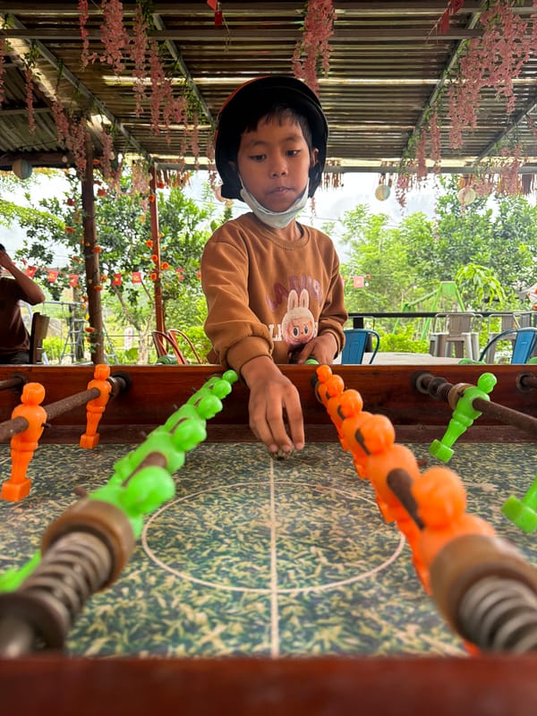Masked child plays foosball at late-night Đà Nẵng cafe