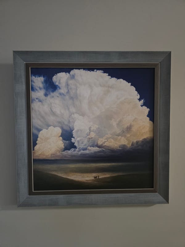 Framed cloud painting observed on gray wall