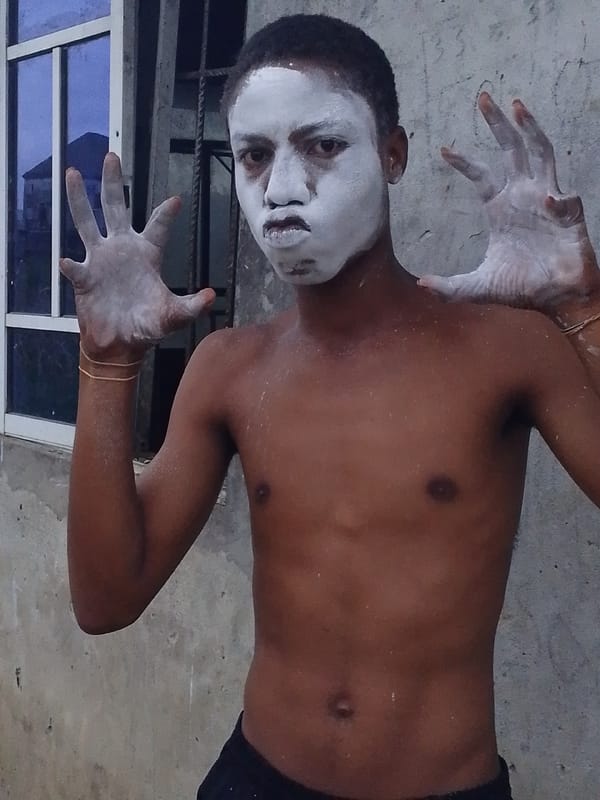 Covered in white powder, posing against a concrete wall
