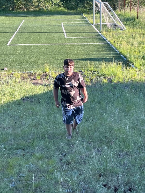 Kids playing summer soccer in rural Siberia, afternoon into sunset